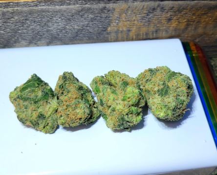 a white plate topped with three pieces of green weed