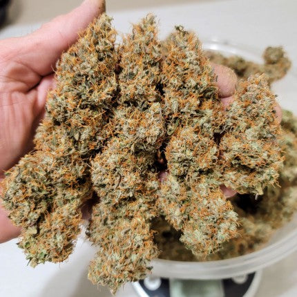a person holding a bowl of weed in their hand